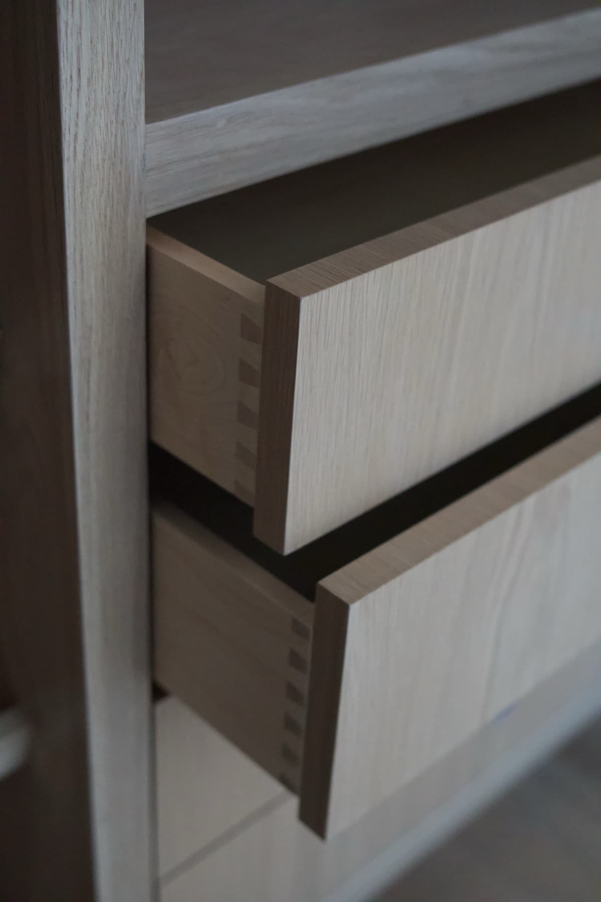 Two open white oak drawers showing hand-cut dovetail joinery at the corners